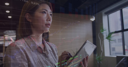 Image of stock market data processing over asian woman using digital tablet at office. Global economy and business data technology conceptの写真素材