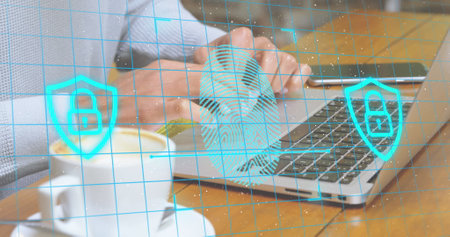 Image of fingerprint, padlock in shields over midsection of caucasian man working on laptop. Digital...