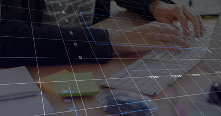 Person typing on keyboard at a desk with a notebook and sticky notes. Overlay of a digital grid suggesting a tech or data-related task, creating a focused work environmentの写真素材