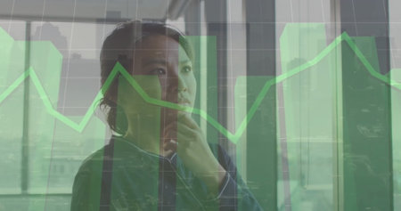 Image of multiple graphs and grid pattern over thoughtful asian woman looking through window. Digital composite, multiple exposure, three dimensional, abstract, report and business concept.の写真素材