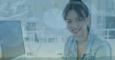 Image of infographic interface over smiling caucasian businesswoman using tablet at desk. Digital...
