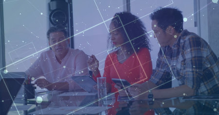 Image of screens with numbers and graphs over diverse colleagues discussing in office. Digital composite, business, report, data, tablet, planning, ideas, teamwork and technology.の写真素材