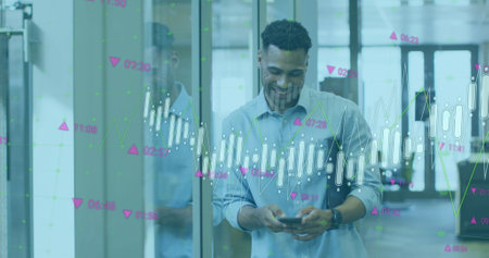 Image of multiple graphs and numbers moving over smiling biracial businessman using mobile phone....