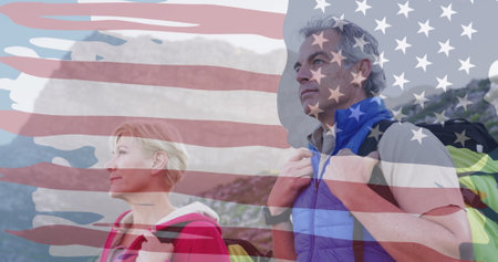 Image of american flag over senior caucasian couple hiking in mountains. patriotism and celebration...