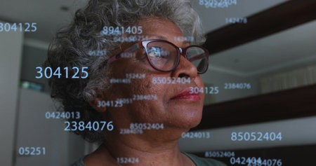 Image of numbers over senior african american woman. global business, finances, connections and digital interface concept digitally generated image.の写真素材