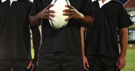 Image of glowing lights over diverse rugby players in sports stadium. rugby, teamwork, sports and competition concept digitally generated image.の写真素材