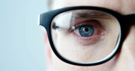 Image of young caucasian male wearing glasses looking intently at something. close-up shot with...