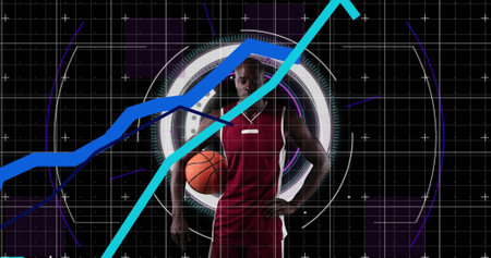 Graphs moving over portrait of african american male basketball player against round scanner. sports and technology conceptの写真素材