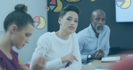 Image of pie graph icons against caucasian woman discussing with her colleagues at office. Computer...