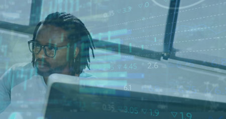 Image of infographic interface over african american businessman with dreadlocks using computer....