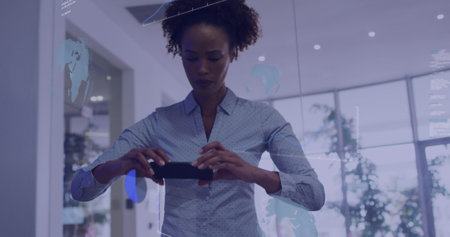 Image of data processing over biracial woman taking a picture using smartphone at office. Computer interface and business data technology conceptの写真素材