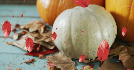 Image of leaves falling over pumpkins. Halloween, celebration and digital interface concept...
