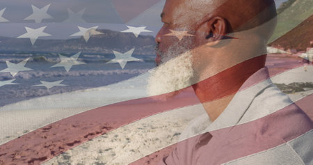 Image of flag of united states of america over senior african american man on beach. american history, patriotism and independence concept digitally generated image.の写真素材