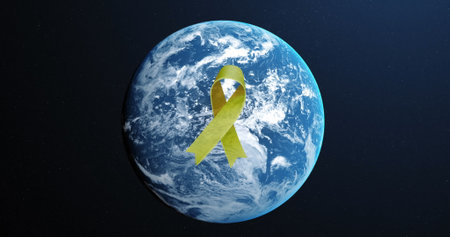 Image of yellow ribbon over globe on blue background, copy space. World suicide prevention day concept digitally generated imageの写真素材