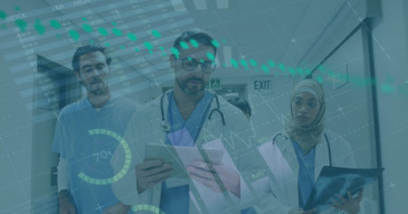 Diverse group of colleagues in medical attire reviewing data on tablet. Hospital corridor with digital graphs overlaying scene, indicating medical analysisの写真素材