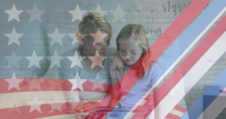 American flag pattern and constitution text against caucasian mother and daughter reading a book. american independence and celebration conceptの写真素材