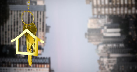 Image of hanging house keys against inverted tall buildings against grey sky. Relocation and real estate conceptの写真素材