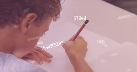 Image of numbers over biracial schoolboy writing. Education, learning, school and data processing concept digitally generated image.の写真素材