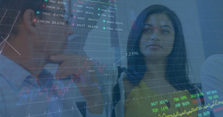 Image of stock market data processing against diverse man and woman discussing at office. Global economy and business data technology conceptの写真素材