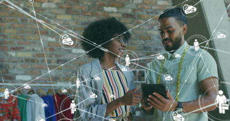 Image of network of connections with icons over diverse business people in office. Global business, finances, computing and data processing concept digitally generated image.の写真素材