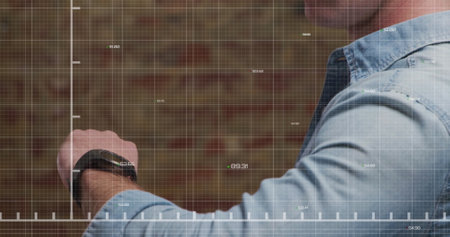 Image of stock market data processing over mid section of caucasian man using smartwatch. Global economy and business technology conceptの写真素材