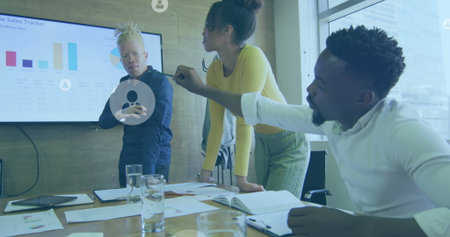 Image of profile icons floating against diverse colleagues discussing together at office. Global...