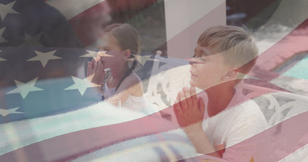 Image of american flag over caucasian family having dinner and praying. patriotism and celebration concept digitally generated image.の写真素材