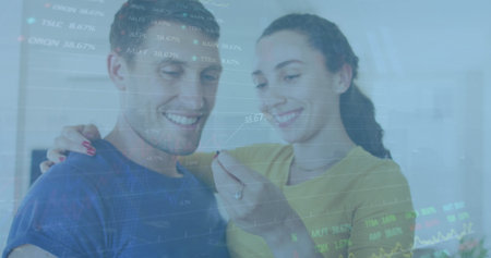 Image of graphs, trading board over caucasian woman holding key and kissing man at home. Digital composite, multiple exposure, report, business, stock market, love, togetherness concept.の写真素材