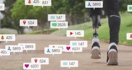Image of notifications, low section of african american man with prosthetic leg jogging in park. Digital composite, social media, leg, run, exercise, fitness, amputee, disability and technology.の写真素材