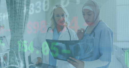 Image of data processing over diverse female doctor and healthworker examining x-ray report. Global...