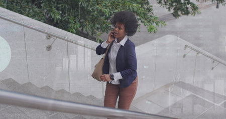 Image of african american woman talking on phone and looking at watch while walking up stairs. Infographic interface, digital composite, report, business, growth, global and technology concept.の写真素材