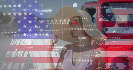 Image of flag of usa over caucasian woman by car on beach. American patriotism, diversity and vacation concept digitally generated image.の写真素材