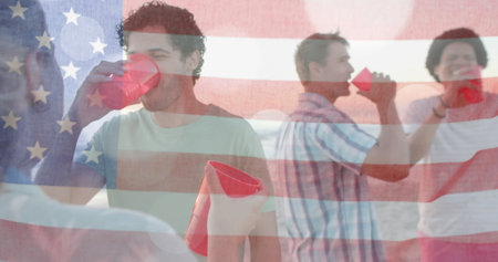 Image of flag of usa over happy diverse friends at beach party in summer. American patriotism, diversity and vacation concept digitally generated image.の写真素材