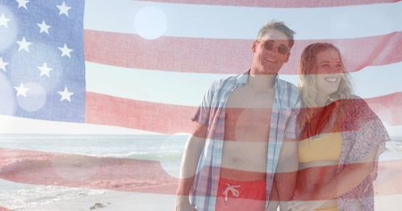 Image of flag of usa over happy caucasian couple on beach in summer. American patriotism, diversity and vacation concept digitally generated image.の写真素材