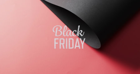 Image of black friday text over rolled up black paper on red background. Black friday, cyber shopping, sales, retail and savings concept digitally generated image.の写真素材