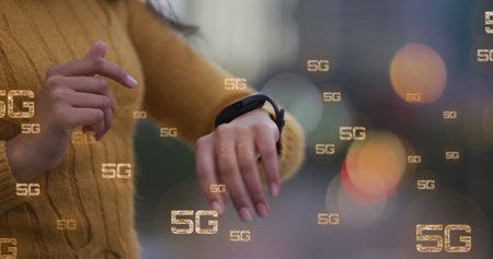 Image of multiple 5g text banners against mid section of a woman using smartwatch outdoors. Global networking and business technology conceptの写真素材