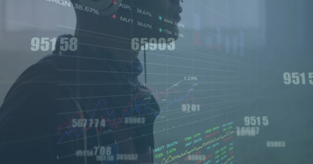Image of graphs, numbers, trading boards, biracial man listening to music wearing headphone. Digital composite, multiple exposure, report, business, stock market and technology concept.の写真素材