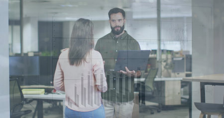 Image of graphs and changing numbers over diverse coworkers standing and discussing in office. Digital composite, multiple exposure, report, business, planning, teamwork and technology concept.の写真素材