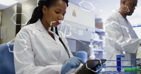 Image of medical data processing on african american female scientist using tablet at laboratory. Medical research and science technology conceptの写真素材