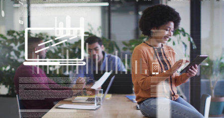 Image of graphs, icons, trading board, biracial woman sitting on desk and using digital tablet. Digital composite, multiple exposure, report, business, stock market and technology concept.の写真素材