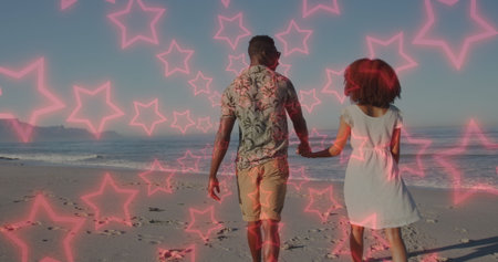 Image of neon stars over back of african american couple walking on beach. romantic love,...