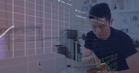 Image of statistical and stock market data processing against asian man using tablet at office. Global economy and business data technology conceptの写真素材