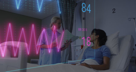 Image of heart rate monitor over diverse female doctor talking to female patient at hospital. Medical healthcare and cancer awareness technology conceptの写真素材