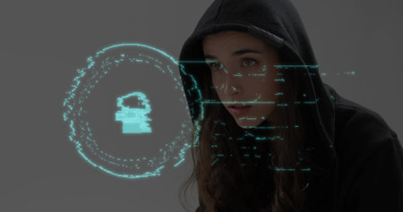 Image of digital interface online security padlock over female hacker in hooded top with laptop. Global technology data security finance business concept digitally generated image.の写真素材