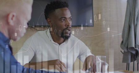 Image of multiple graphs over diverse man sharing ideas with coworkers in office. Digital composite,...