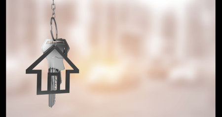 Image of key with house keychain over blurred background. Moving house concept digitally generated image.の写真素材