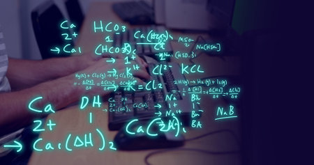 Image of equations and data processing over biracial male student using computer. Global education, learning, school, digital interface and data processing concept digitally generated image.の写真素材