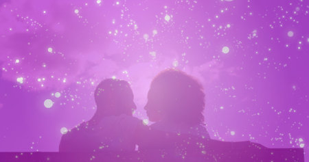 Image of light spots over biracial couple embracing. Holidays, free time and love concept digitally generated image.の写真素材