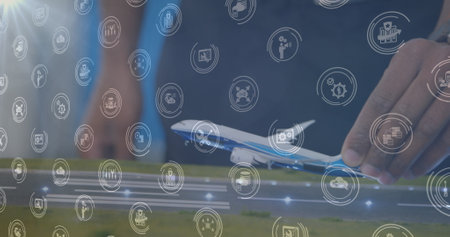 Image of digital icons over mid section of a woman flying a airplane model at office. Business engineering and aviation technology conceptの写真素材