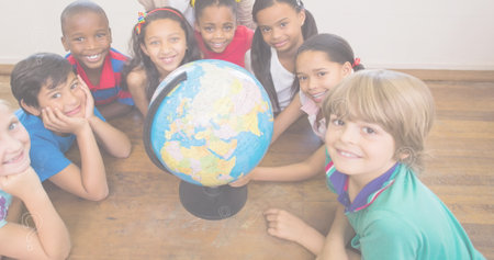 Diverse students gather around a globe at school. The group shows curiosity and eagerness to learn about different countries.の写真素材